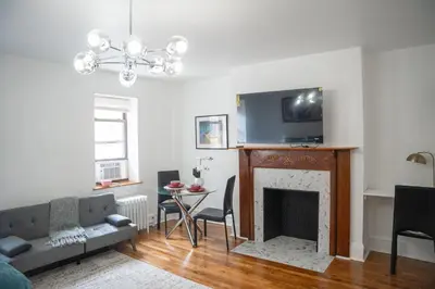 a living room with a fireplace and a tv at Harlem Muse in New York