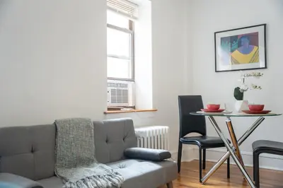 a living room with a couch and a table with chairs at Harlem Muse in New York