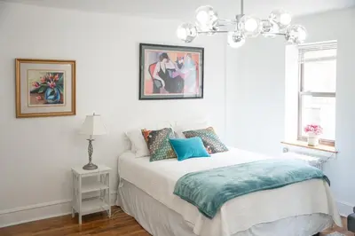 a bedroom with a bed with a blue blanket on it at Harlem Muse in New York