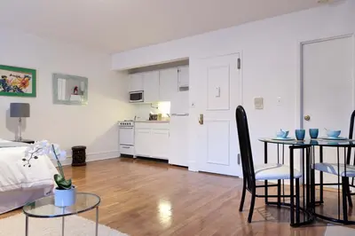 a living room with a bed and a table and chairs at Historic Striver's Row Apartment in New York