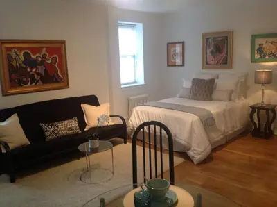 a living room with a bed and a couch at Historic Striver's Row Apartment in New York