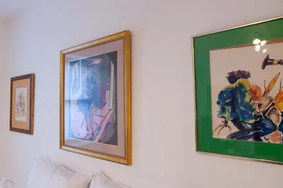 three pictures on a wall above a couch at Historic Striver's Row Apartment in New York