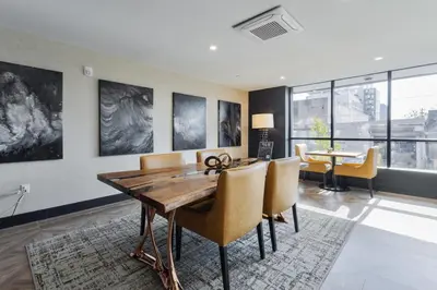 a dining room with a wooden table and chairs at Luxe Loft 15 Min from NYC with City View & Gym in Jersey City