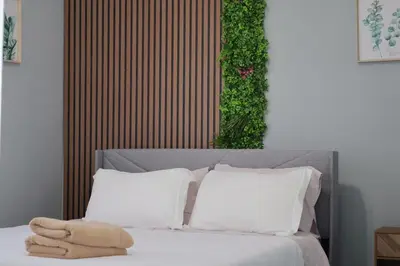 a bed with two white pillows and a green wall at Cozy Home, 19m to NYC, 10m to American Dream in Wallington