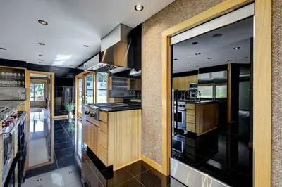 a kitchen with wooden cabinets and a large window at Longpond House in Salisbury