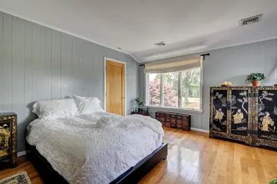 a bedroom with a bed and a large window at Longpond House in Salisbury