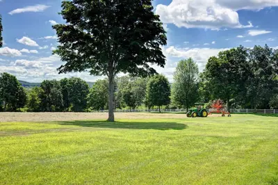 a tractor in a field with a tree at Longpond House in Salisbury