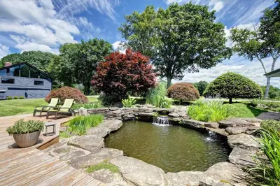 a garden with a pond and a wooden deck at Longpond House in Salisbury