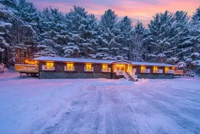 a home in the snow with lights on at Pond House at Carter Bridge Estate in Freehold