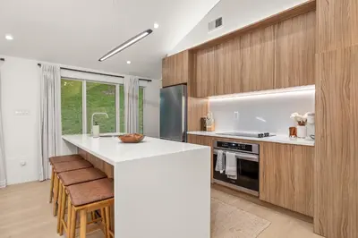 a kitchen with a white counter and wooden cabinets at Pond House at Carter Bridge Estate in Freehold