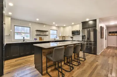 a kitchen with a large island with bar stools at Hot Tub Pool & Pond - Catskills Family Escape in Cairo