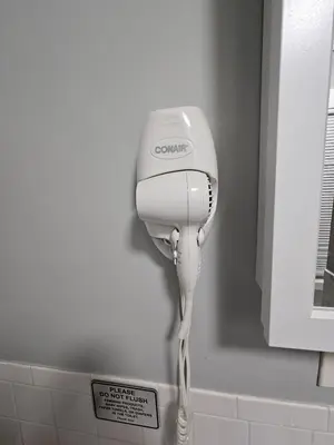 a hair dryer hanging on the wall in a bathroom at Entire Spacious House in New Jersey in East Orange
