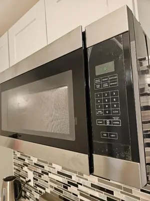 a microwave oven over a stove in a kitchen at Entire Spacious House in New Jersey in East Orange
