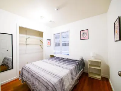 a white bedroom with a bed and a window at Bright Private Room with Shared Bathroom near NYC in Jersey City
