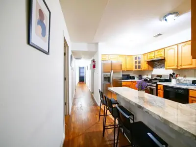 a kitchen with wooden cabinets and a counter top at Bright Private Room with Shared Bathroom near NYC in Jersey City