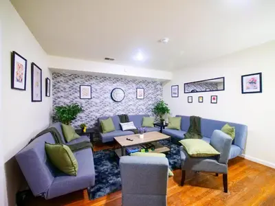 a living room with blue couches and a table at Mins to NYC Comfy Private Room in Shared Home in Jersey City
