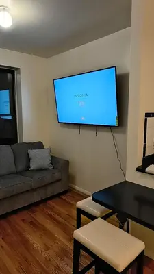 a living room with a couch and a flat screen tv at The Park Ave Studio in New York