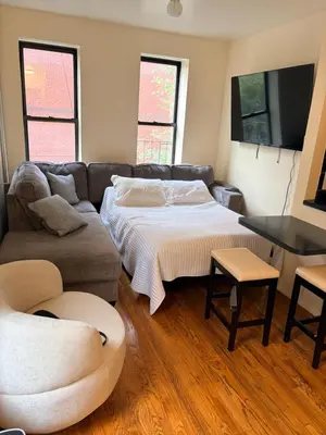 a living room with a bed and a couch at The Park Ave Studio in New York