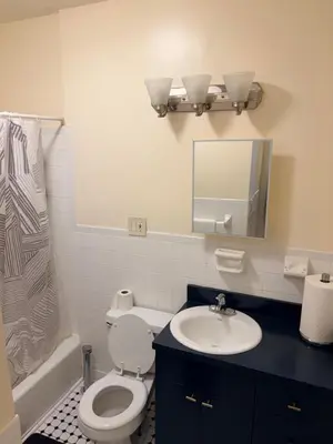 a bathroom with a toilet and a sink and a mirror at The Park Ave Studio in New York