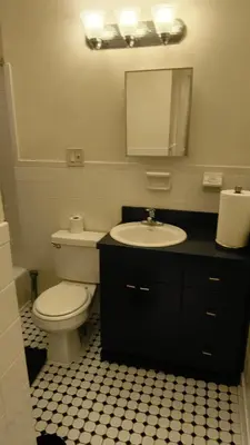 a bathroom with a toilet and a sink and a mirror at The Park Ave Studio in New York