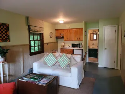 a living room with a white couch and a kitchen at The Mountain Brook Inn in Bovina Center