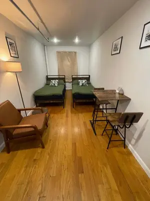 a room with two beds and a table and chairs at Union Square Studio with Kitchen -Shared Bathroom in New York