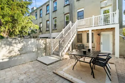 a patio with a table and chairs in front of a building at Elegant Home w Patio | In-Unit Laundry Near NYC in Jersey City