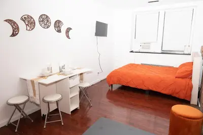 a bedroom with a bed and a desk with stools at West Village Escape - Steps from Subway Cafes in New York