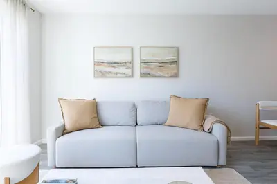 a living room with a couch and two paintings on the wall at Downtown 2BR Gem Yale Wooster Sq WiFi in New Haven