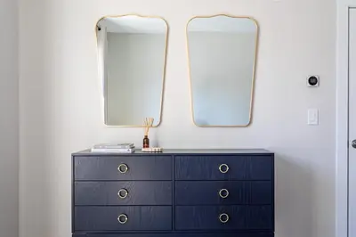 a black dresser with two mirrors on top of it at Downtown 2BR Gem Yale Wooster Sq WiFi in New Haven