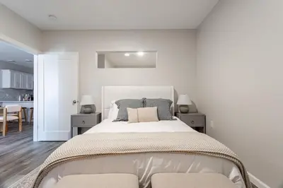 a white bedroom with a large bed with two tables at Downtown 2BR Gem Yale Wooster Sq WiFi in New Haven