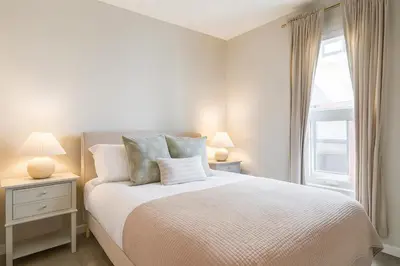 a white bedroom with a bed and a window at Downtown 2BR Gem Yale Wooster Sq WiFi in New Haven