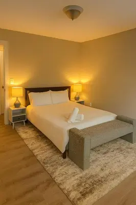a bedroom with a large white bed with two lamps at Modern 2BR Westville Downtown Near Yale Wifi in New Haven