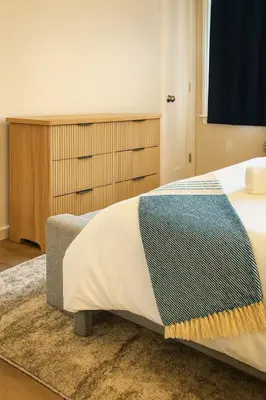 a bedroom with a bed with a blanket on it at Modern 2BR Westville Downtown Near Yale Wifi in New Haven