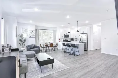 a white living room with a couch and a table at Newly Built Lake House Near NYC EWR MetLife AD Mall in Passaic
