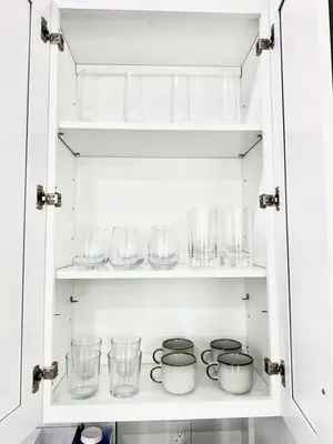 a cupboard filled with glasses and other glass items at Newly Built Lake House Near NYC EWR MetLife AD Mall in Passaic