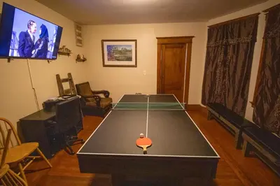 a living room with a ping pong table and a tv at Cozy Apartment in Artsy Westville New Haven in New Haven