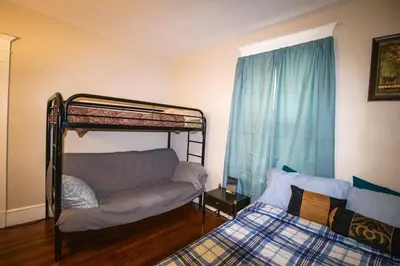 a bedroom with a bunk bed and a bed and a couch at Cozy Apartment in Artsy Westville New Haven in New Haven