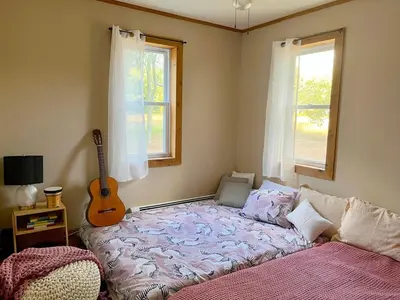 a bedroom with a bed and a guitar in it at Cozy Creek House in Forestburgh