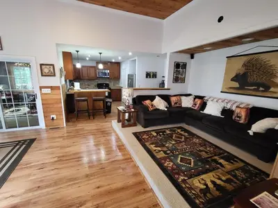 a living room with a black couch and a kitchen at Romantic Retreat with a Jacuzzi 