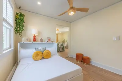 a bedroom with a white bed with two yellow pillows at Zen Den With King Bed and Very Close to Airport in Newark