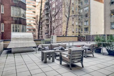 a patio with benches and a fountain and buildings at Blueground Murray Hill fitness center nr Bryant Park NYC-1939 in New York