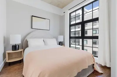 a white bedroom with a large bed and a window at Blueground Williamsburg rooftop nr East River NYC-1942 in Brooklyn