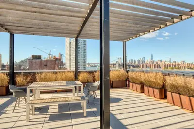 a patio with a table and chairs on a roof at Blueground Williamsburg rooftop nr East River NYC-1942 in Brooklyn