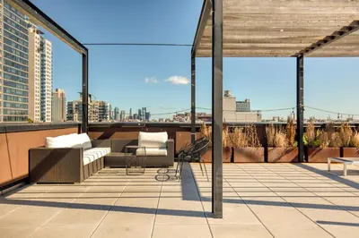 a rooftop patio with furniture and a view of the city at Blueground Williamsburg rooftop nr East River NYC-1942 in Brooklyn