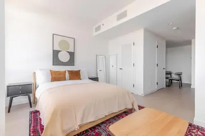 a white bedroom with a bed and a table at Blueground Southside doorman nr Brooklyn Bridge NYC-2132 in Brooklyn