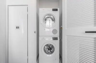 a washer and dryer in a white room at Blueground Southside doorman nr Brooklyn Bridge NYC-2132 in Brooklyn