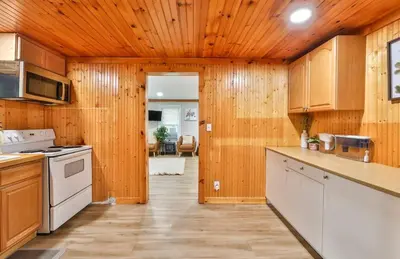 a kitchen with wooden walls and wooden flooring at Group Getaway 1 Mile From Hunter Mtn with Fire Pit in Hunter