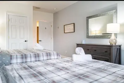 a bedroom with two beds and a mirror and a dresser at Modern Hunter Mountain Condo Steps from Slopes in Hunter