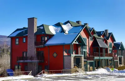 a row of houses with snow on the roofs at Modern Hunter Mountain Condo Steps from Slopes in Hunter